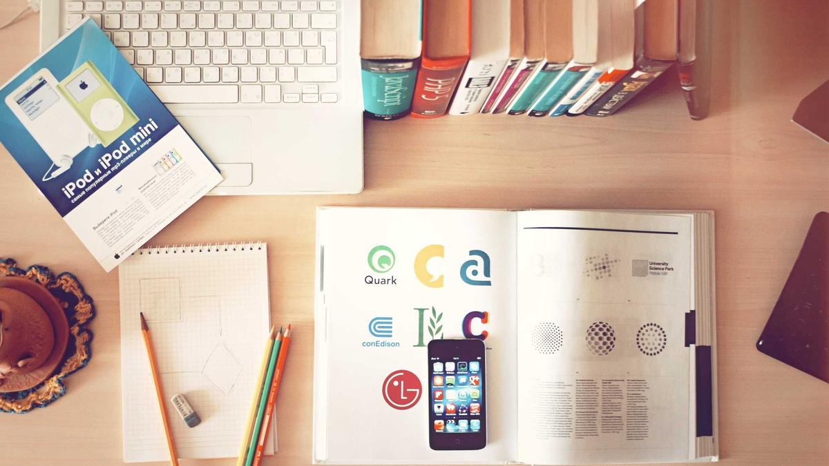 Desk with notebook, phone and office supplies